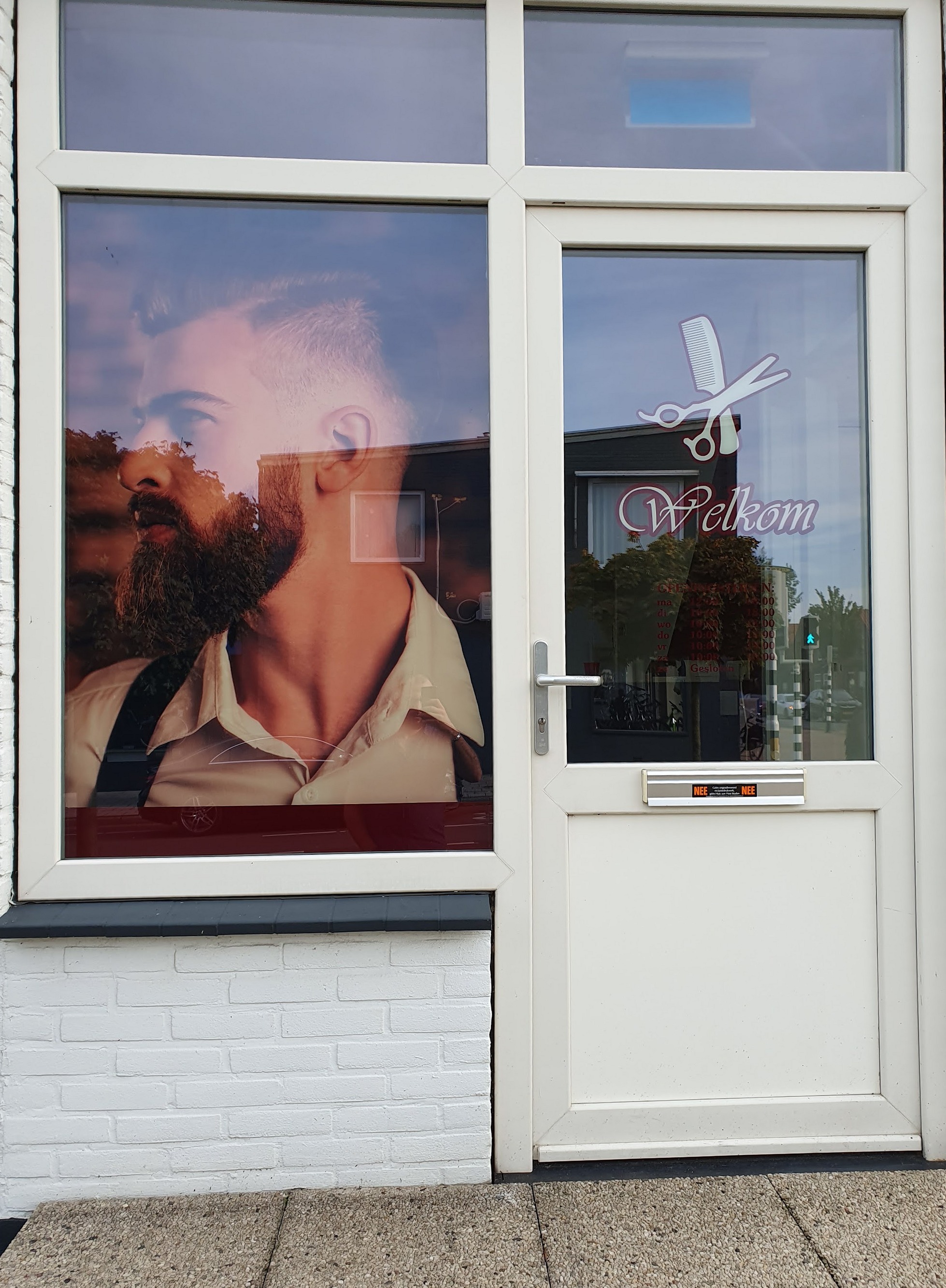 De voordeur van Kapsalon Oscar met Welkom op het glas